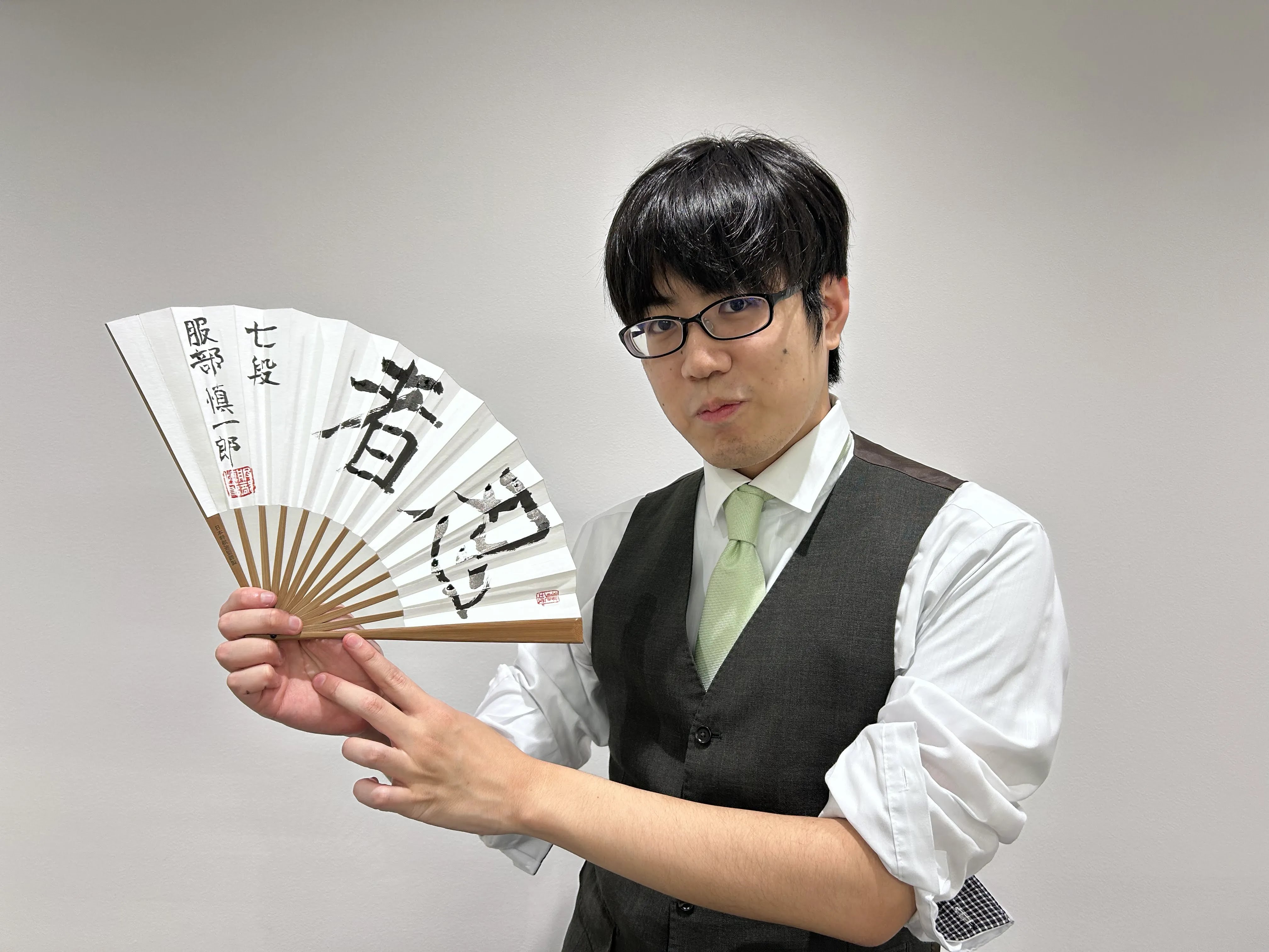 直筆扇子を持つ服部慎一郎七段
